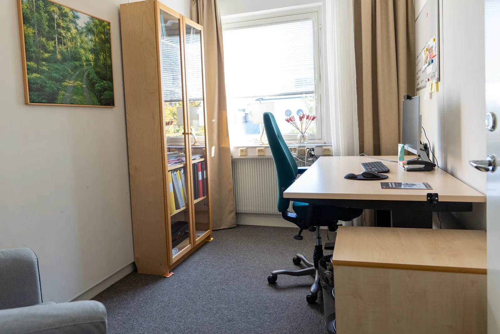 Det lilla kontorsrummet på sju kvadratmeter med skrivbord, kontorsstol, bokhylla och fönster