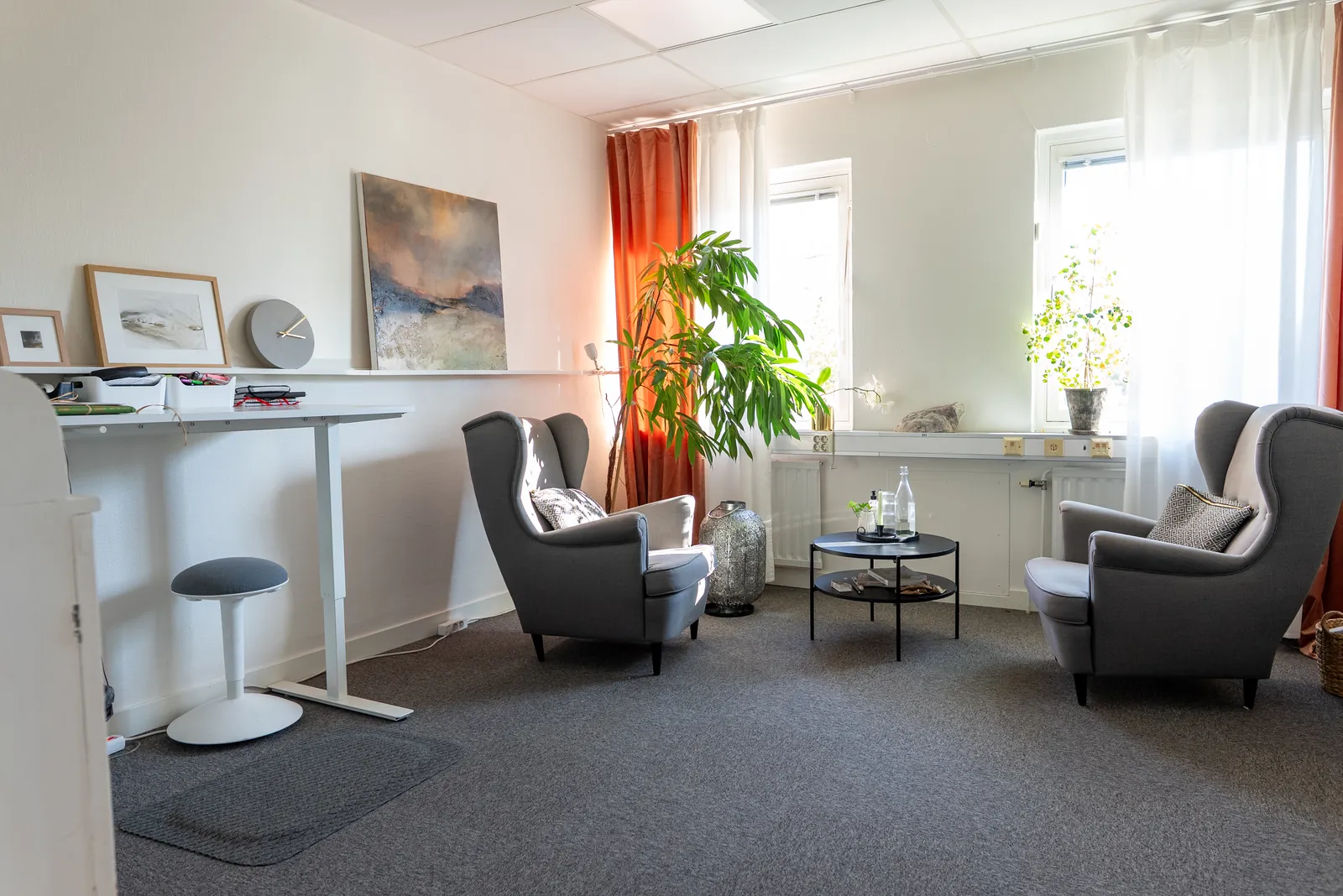 Det stora kontorsrummet på femton kvadratmeter med två fåtöljer, soffbord och skrivbord vid fönstren